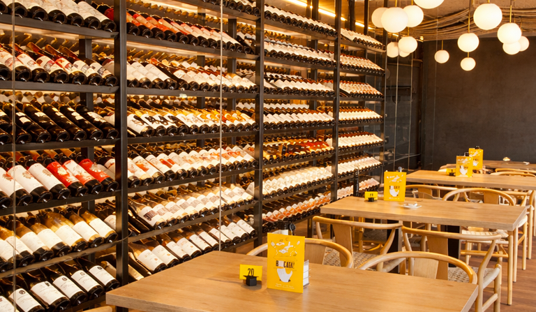 Menjador d'OH TAPA! La Garriga amb un gran celler vist, una extensa selecció de vins i un ambient modern per gaudir de tapes, dinars i sopars.